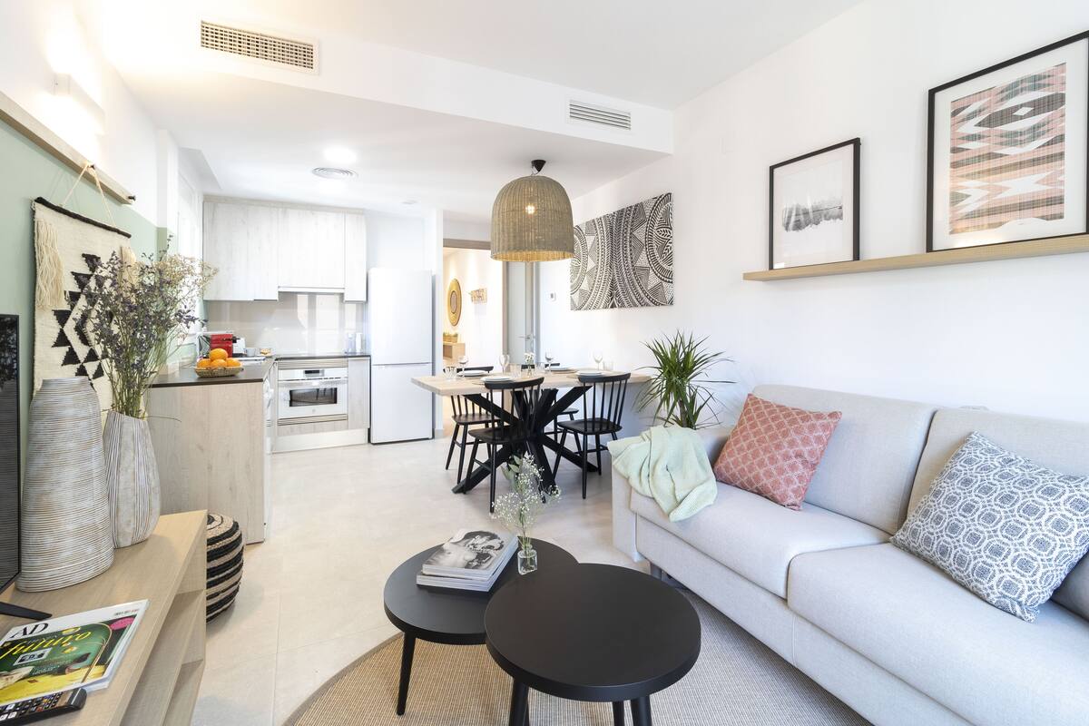 Una sala de estar moderna con un sofá, una mesa de centro y un comedor con sillas y una mesa.