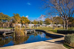 A tranquil park with a pond, pathways, and trees. - Calafell Home Apartments (Calafell)