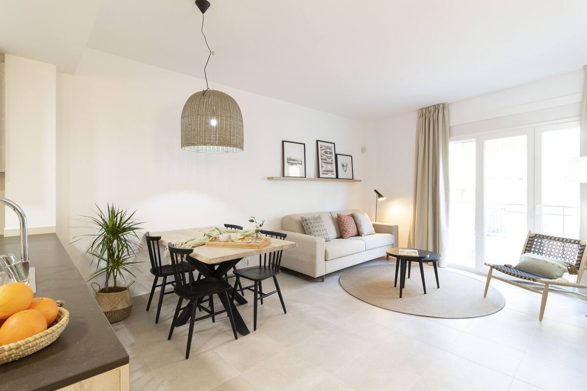 Una sala moderna con comedor, un sofá y una silla.