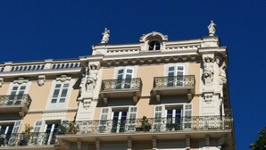 A multi-story building with ornate balconies, classical statues, and a clear blue sky. - Cosy studio with a view, central & quiet area (Aix-les-Bains)