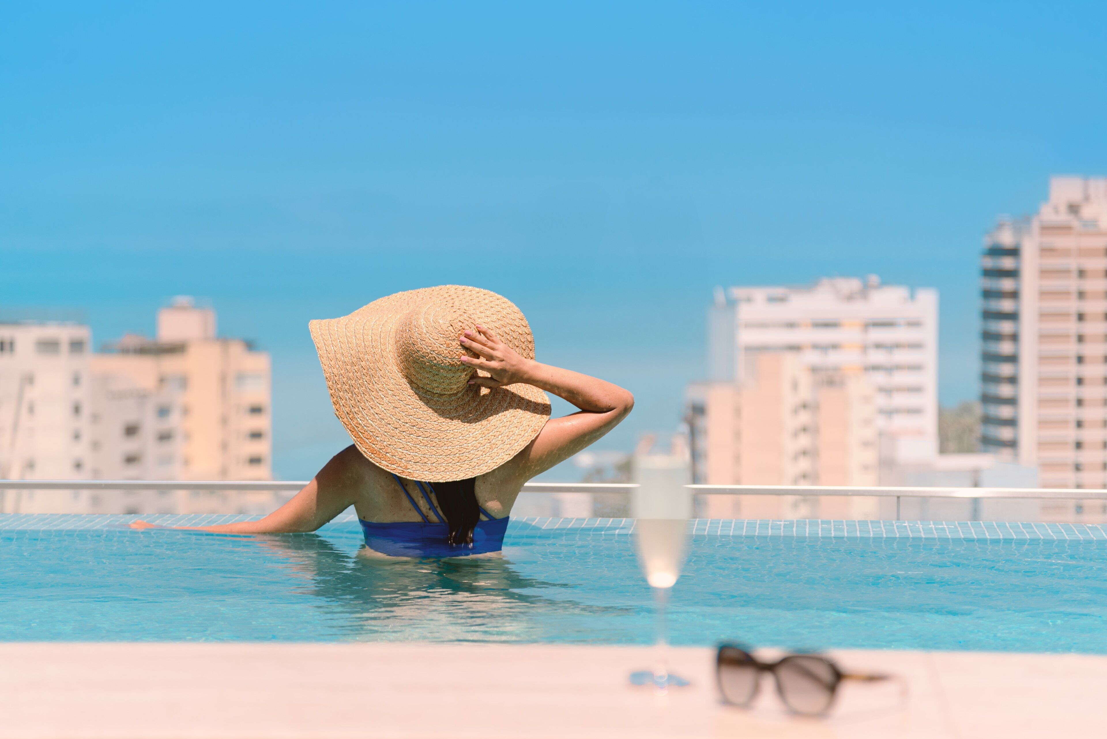 Une personne dans une piscine, avec une vue sur la ville en arrière-plan.