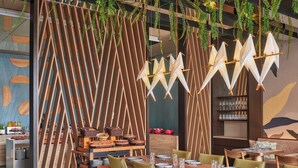 A modern restaurant with wooden furniture, hanging plants, and a unique wall design. - Souma Hotel, Vignette Collection by IHG (Lima)
