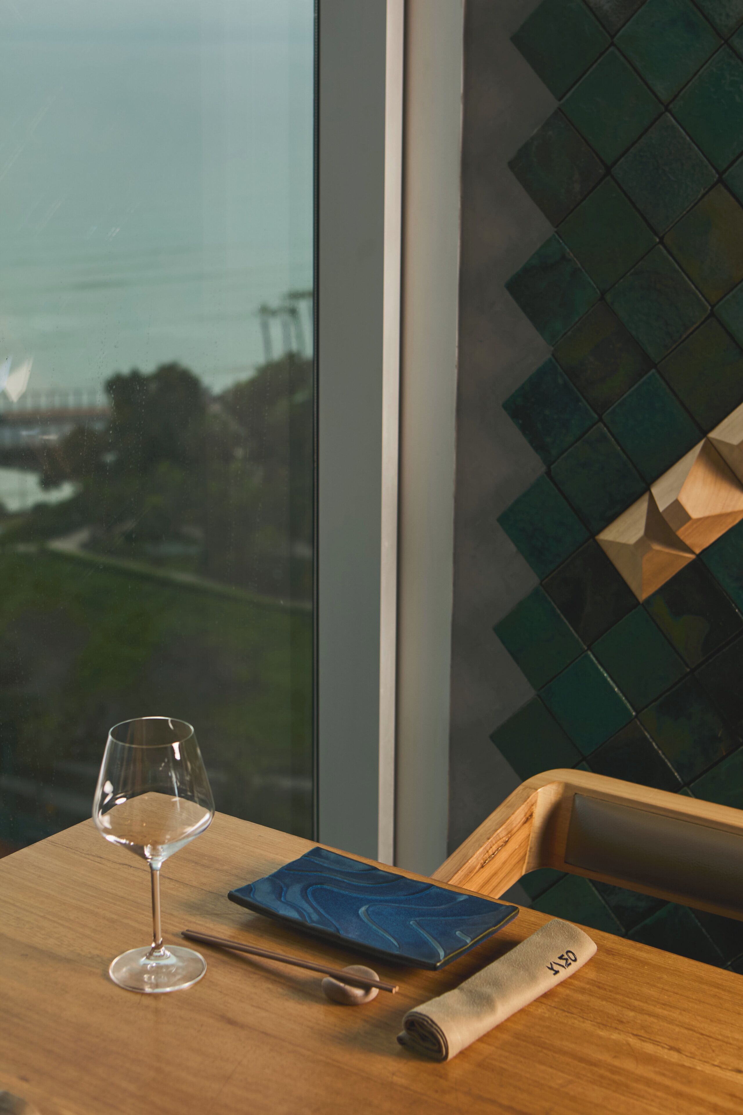 A table with a glass of wine, a book, and a rolled-up menu.