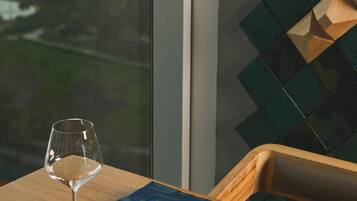 Una mesa con una copa de vino, un libro y un menú enrollado.
