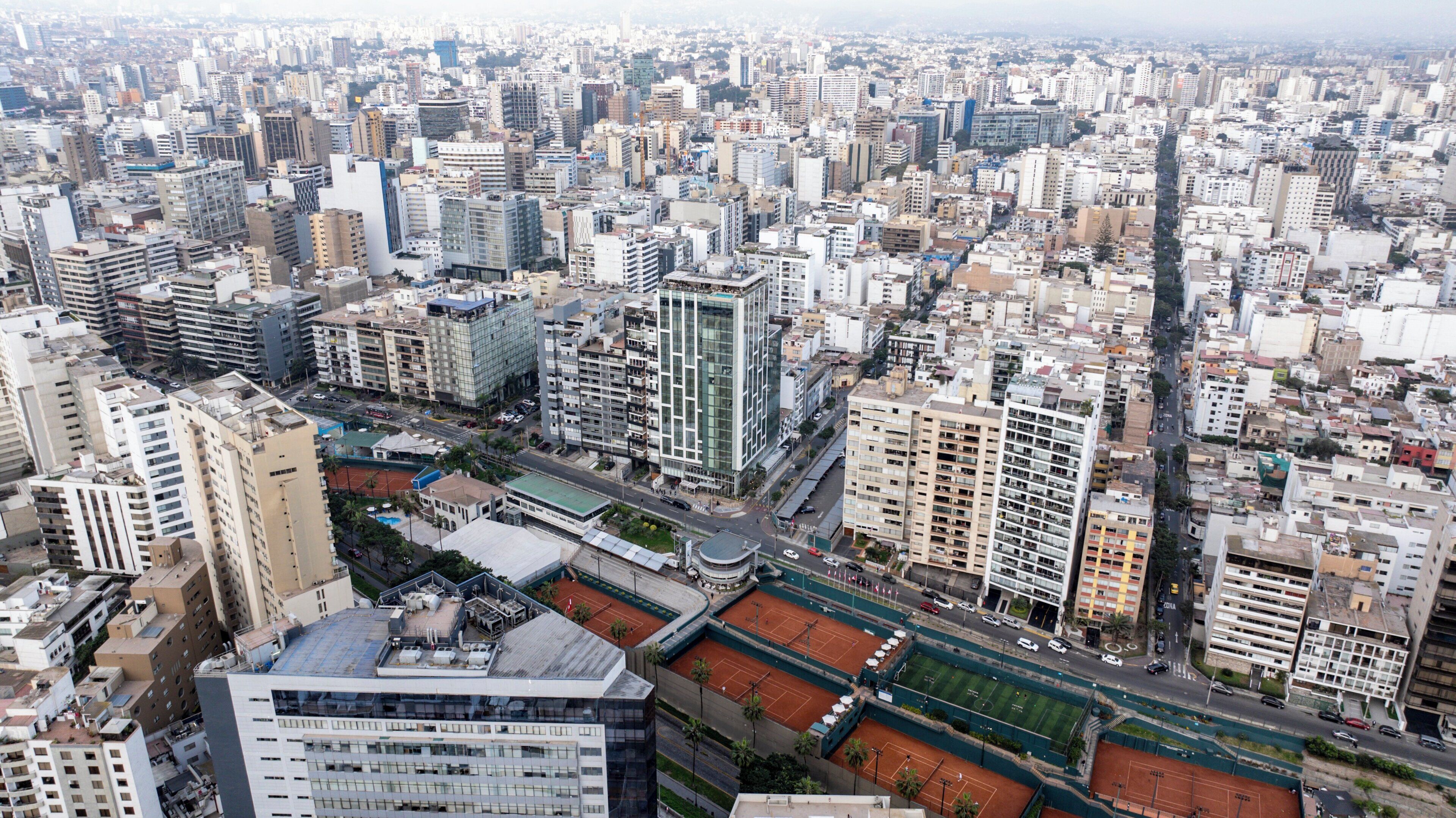 Un immeuble de grande hauteur, composé de nombreux étages, situé dans un environnement urbain dense et entouré d’autres immeubles de grande hauteur.