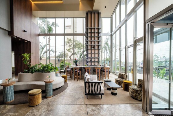 A spacious indoor area with a bar, seating, and large windows.