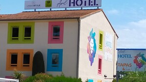 A colorful building with a sign that reads "Art Hotel" and "Tapas & Co." - Arl Hotel (Arles)