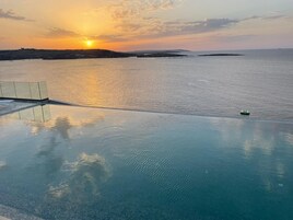 Una piscina techada, una piscina al aire libre de temporada, sombrillas