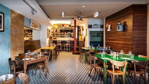 A restaurant with a checkered floor, wooden tables, and chairs. - Seaview Hotel Malta - Adults Only (St. Paul's Bay)
