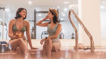 Una piscina cubierta, una piscina al aire libre de temporada, sombrillas