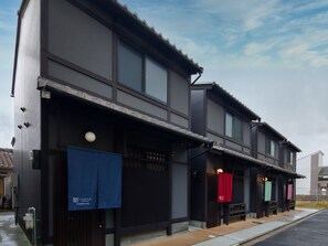 Il s'agit d'un bâtiment japonais traditionnel doté d'une façade moderne, avec une grande entrée comprenant des portes coulissantes et un petit espace de véranda.