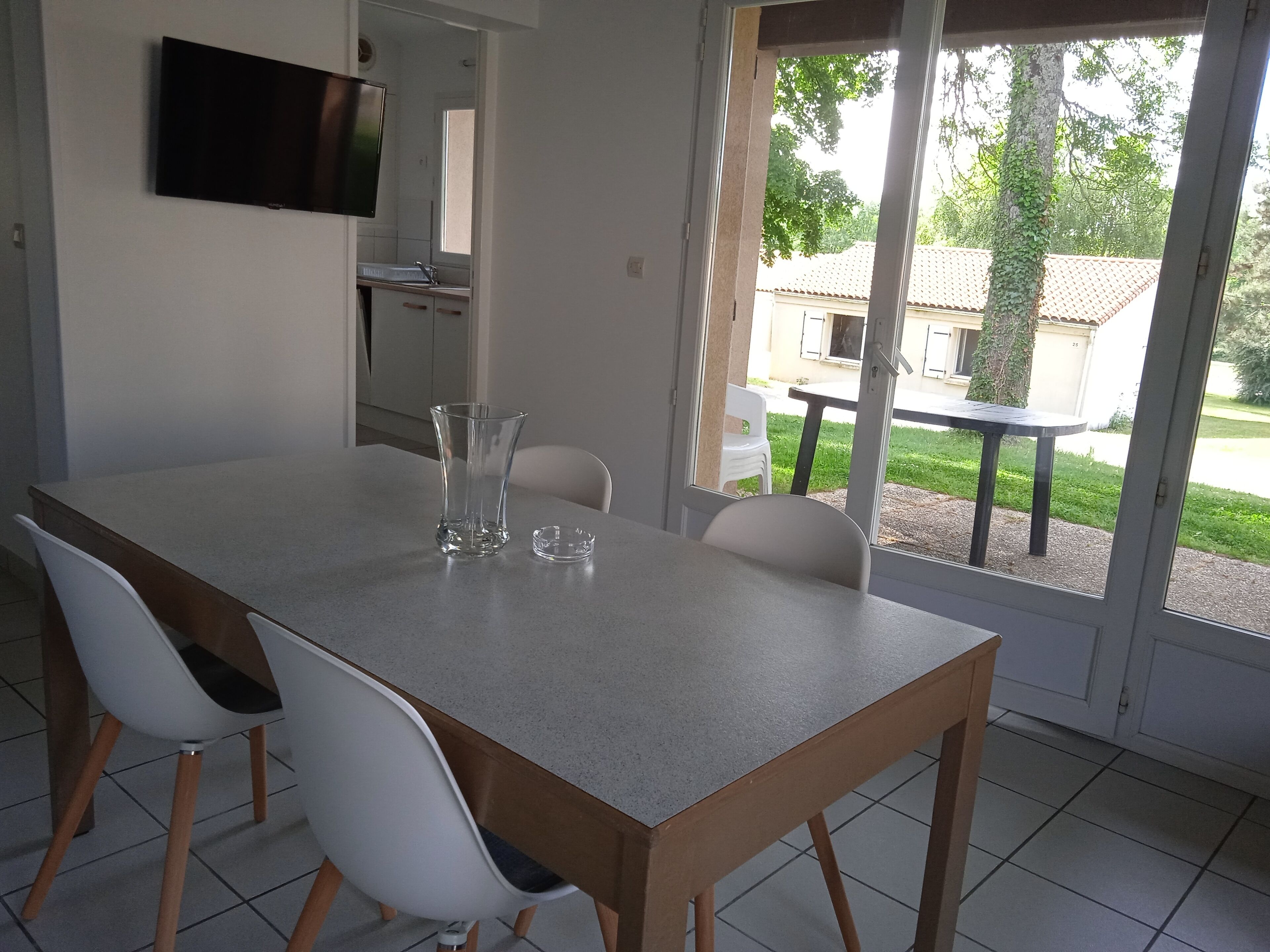 A dining area with a table, chairs, and a view of the outdoors.