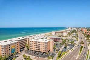 Ein Hotel direkt am Strand mit mehreren Etagen, Parkplätzen und Meerblick.
