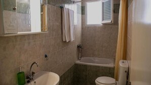 Een badkamer met een wastafel, toilet en bad.