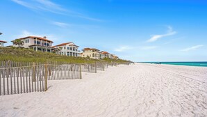 A beachfront property with multiple houses, a sandy beach, and a clear blue sky. - Remodeled 5BR Beachfront Home w/ new main floor deck, Private Beach, Communal Pool & Bunks (Santa Rosa Beach)