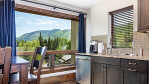 A kitchen with a view of mountains, a coffee maker, and a dishwasher. - Heart of Lionshead + Free Parking - Rooftop Hot Tub (Vail)