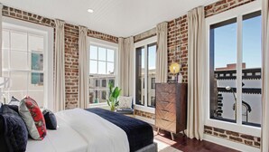 Ein Schlafzimmer mit einem großen Bett, einem Schminktisch und Blick ins Freie.