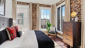Ein Schlafzimmer mit Bett, Schminktisch, Stuhl und einem Vorhangfenster.
