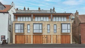 Un bâtiment à deux étages, doté d’un toit plat, de grandes fenêtres et de portes en bois.