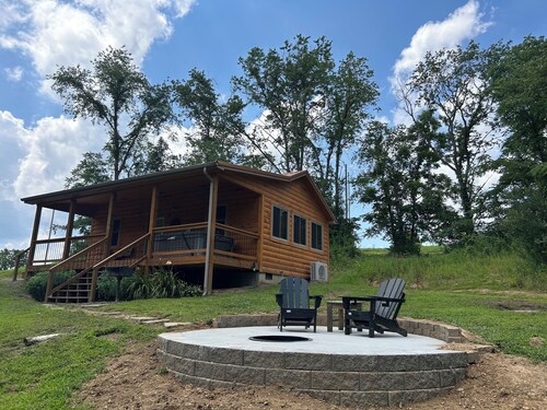 A cozy new cabin in rural setting with a hot tub on porch. Beautiful rural view.