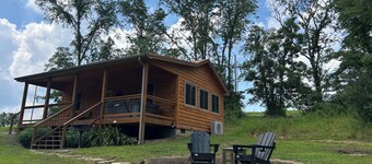 A cozy new cabin in rural setting with a hot tub on porch. Beautiful rural view.