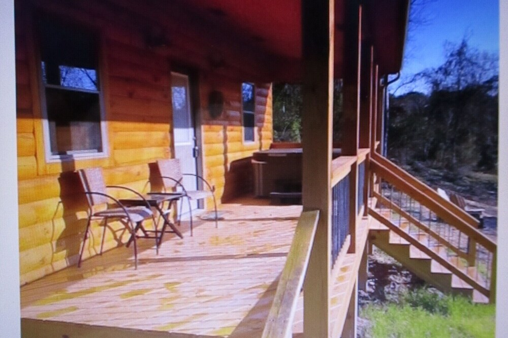 A cozy new cabin in rural setting with a hot tub on porch. Beautiful rural view.