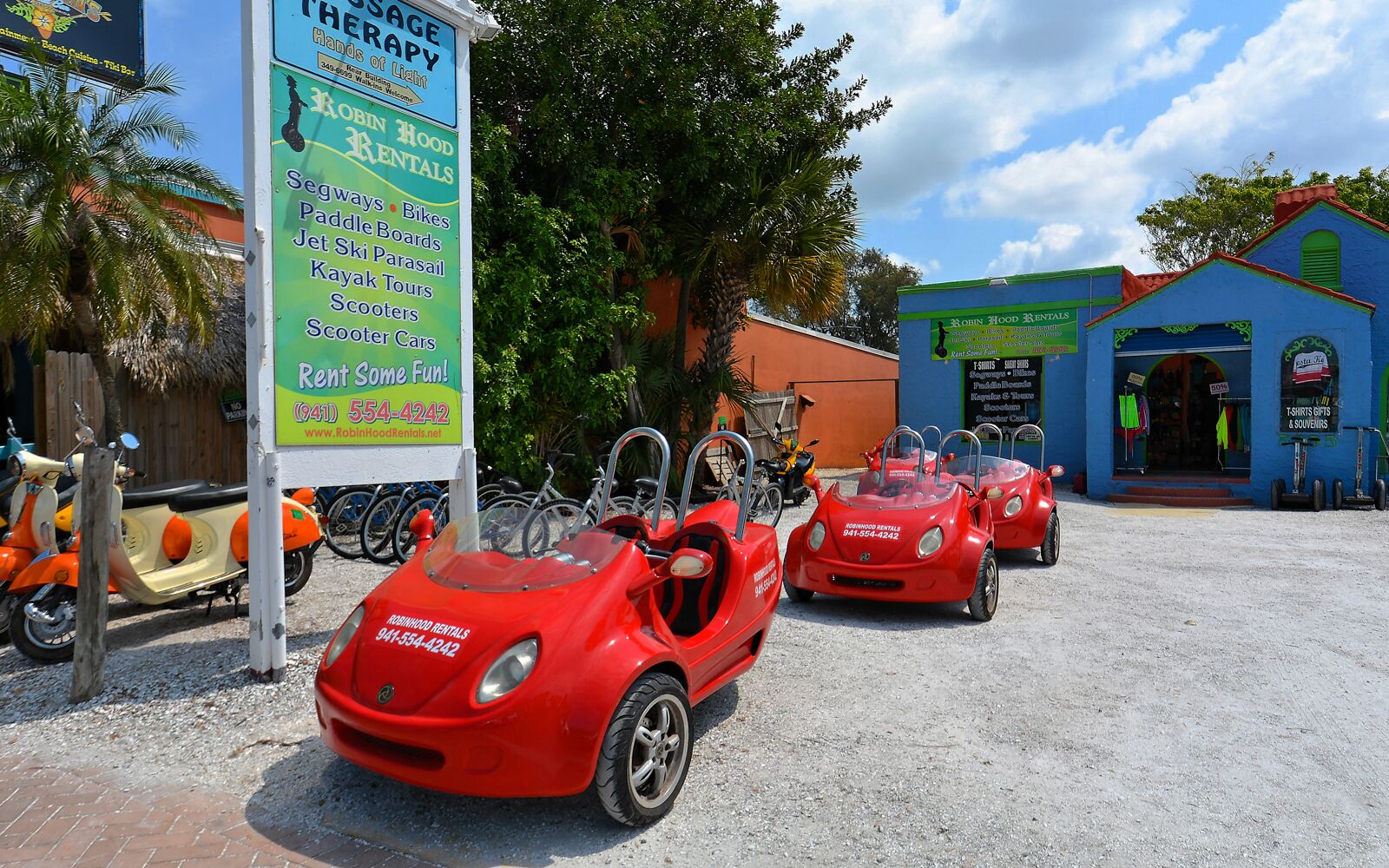 A rental car service with a sign listing available activities like Segways, bikes, paddleboards, and more.