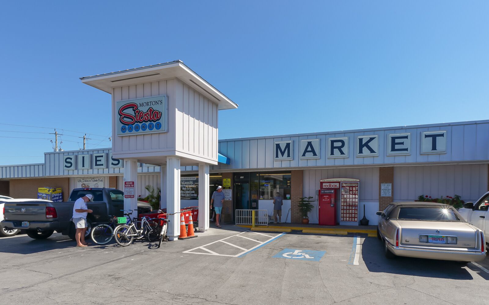 A market with a sign for Morton's Siesta Market, a red mailbox, and a handicapped parking space.