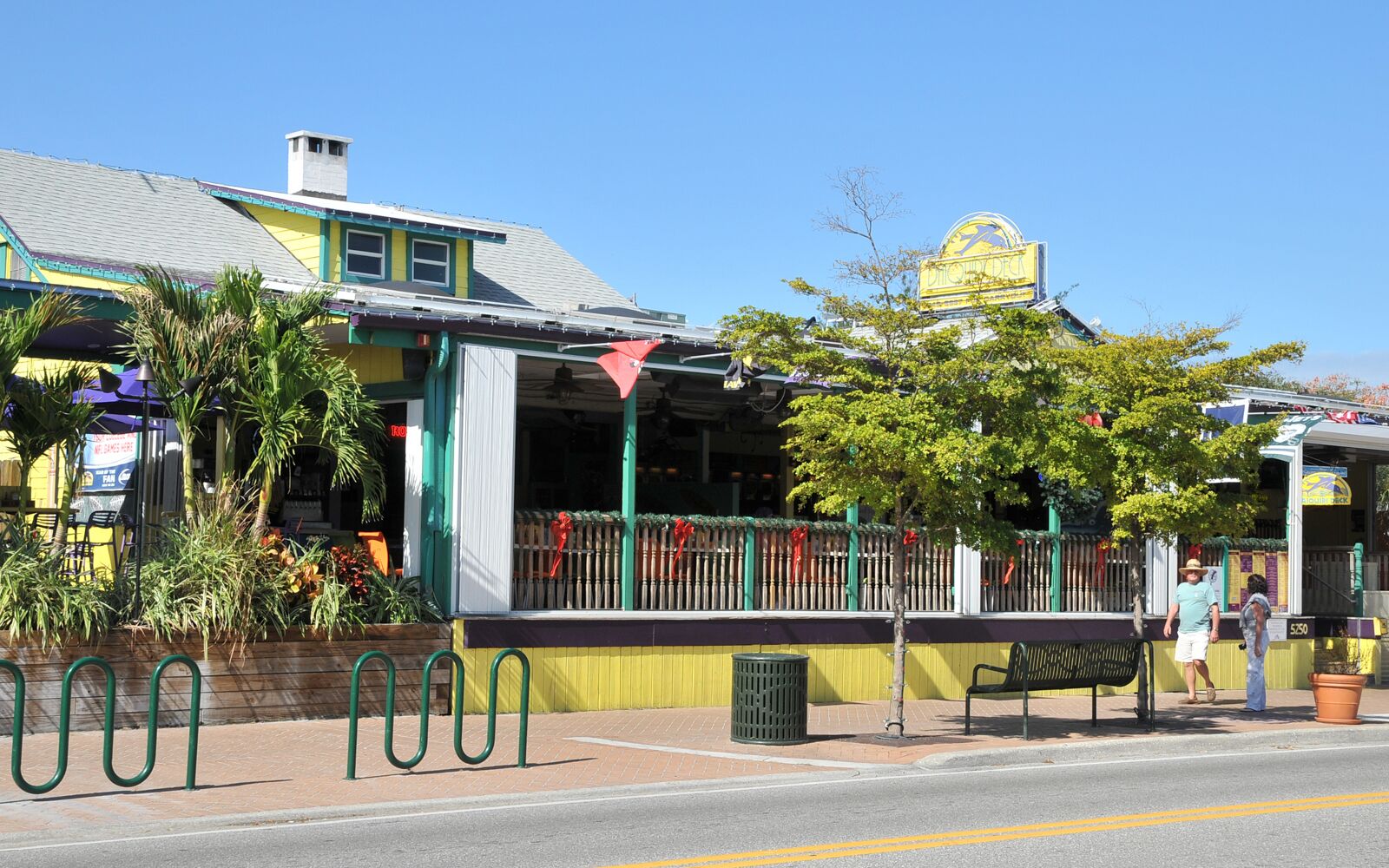 A building with a yellow facade, a green awning, and a sign with a blue 'K' logo.