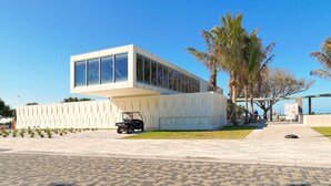 A modern building with a large glass facade and the name "SIESTA BEACH" on the side. - Siesta Key Village -Suite #2: A Block to the Beach, In the HEART of the Village! (Sarasota)