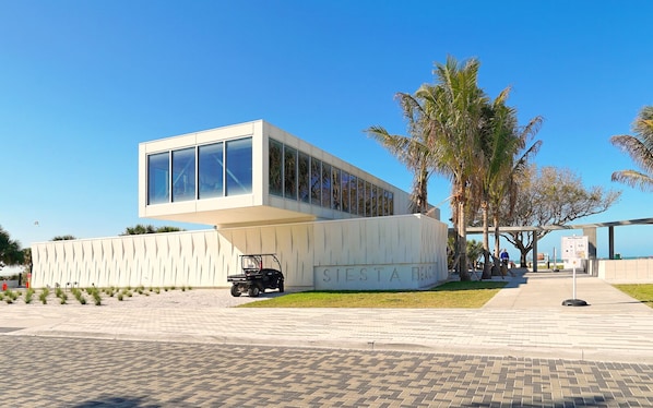 A modern building with a large glass facade and the name "SIESTA BEACH" on the side.