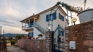 A two-story house with a stone wall, a balcony, and a gate. - Koroni Seaview Retreat - Summer Romantic Escape (Koroni)