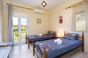 A bedroom with two beds, a balcony, and a view of the outdoors. - Koroni Seaview Retreat - Summer Romantic Escape (Koroni)