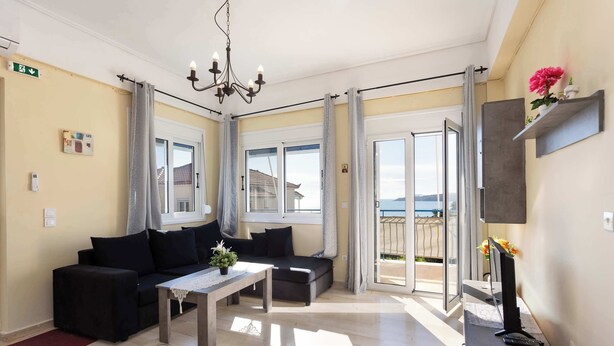 A modern living room with a sofa, a coffee table, and a TV stand. - Koroni Seaview Retreat - Summer Romantic Escape (Koroni)