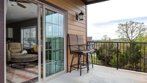 A balcony with a glass door leading to a living area, a ceiling fan, and a view of trees. - 51-05 Lake view unit Close to SDC Indoor/Outdoor pools (Branson)