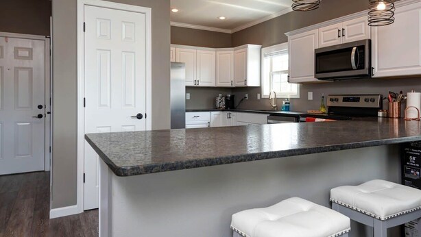 A modern kitchen with white cabinets, a granite countertop, and pendant lighting. - 51-05 Lake view unit Close to SDC Indoor/Outdoor pools (Branson)