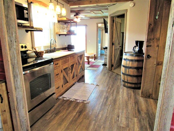 Una cocina rústica con armarios de madera, estufa de acero inoxidable y cafetera.