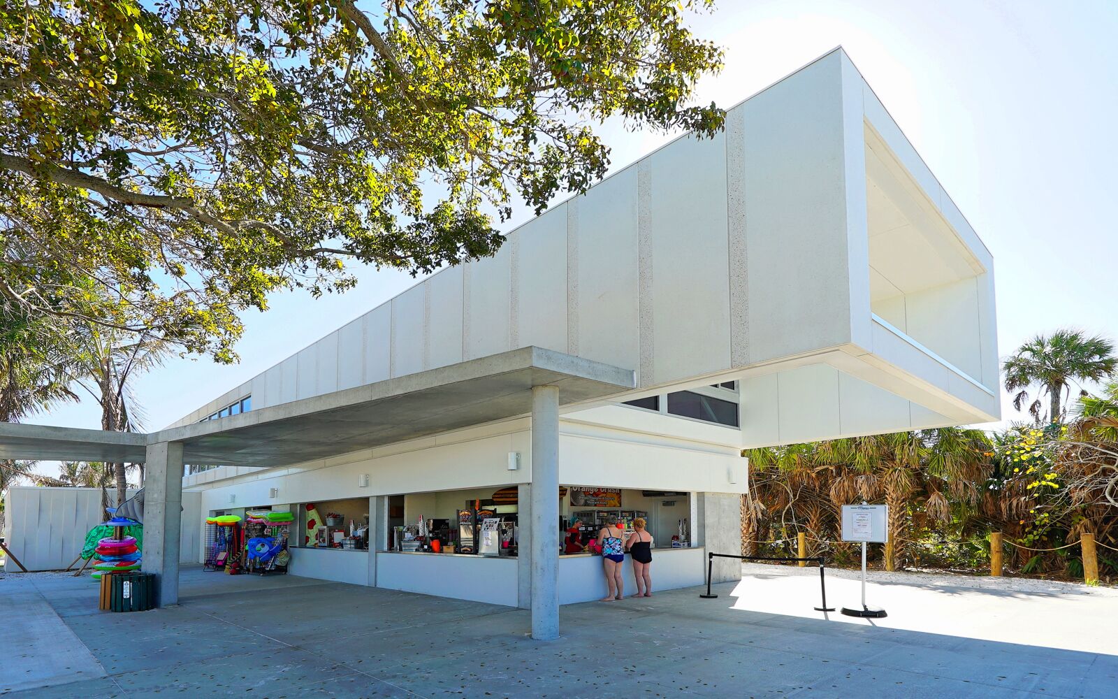 A modern building with a flat roof and a covered outdoor area.