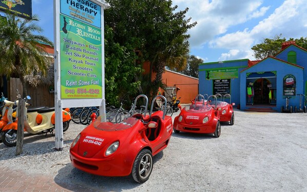 A rental car service with a sign listing available activities like Segways, bikes, paddle boards, and more. - Siesta Cool : Only Minutes Walk to Siesta Beach! (Siesta Key)