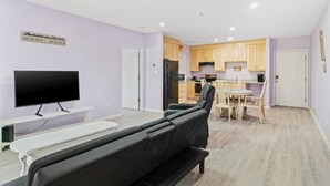Un salon équipé d’un téléviseur, d’un canapé et d’un coin repas avec une table et des chaises.