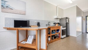A modern kitchen with a microwave, kettle, and stainless steel appliances. - Windsurfer Beach Chalet  2 - No Frills holiday vibe (Lancelin)