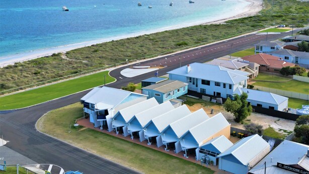 A coastal property with a road leading to a beach, a parking lot, and a building with a unique blue roof. - Windsurfer Beach Chalet  2 - No Frills holiday vibe (Lancelin)