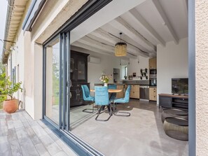 A modern kitchen with a dining area, featuring a sliding glass door leading to an outdoor patio.