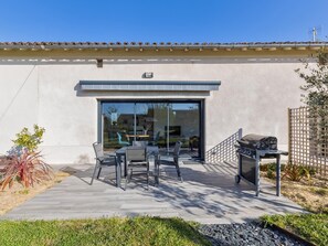 A patio with outdoor furniture and a barbecue grill.
