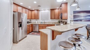 Una cocina moderna con armarios de madera, electrodomésticos de acero inoxidable y encimera de granito.