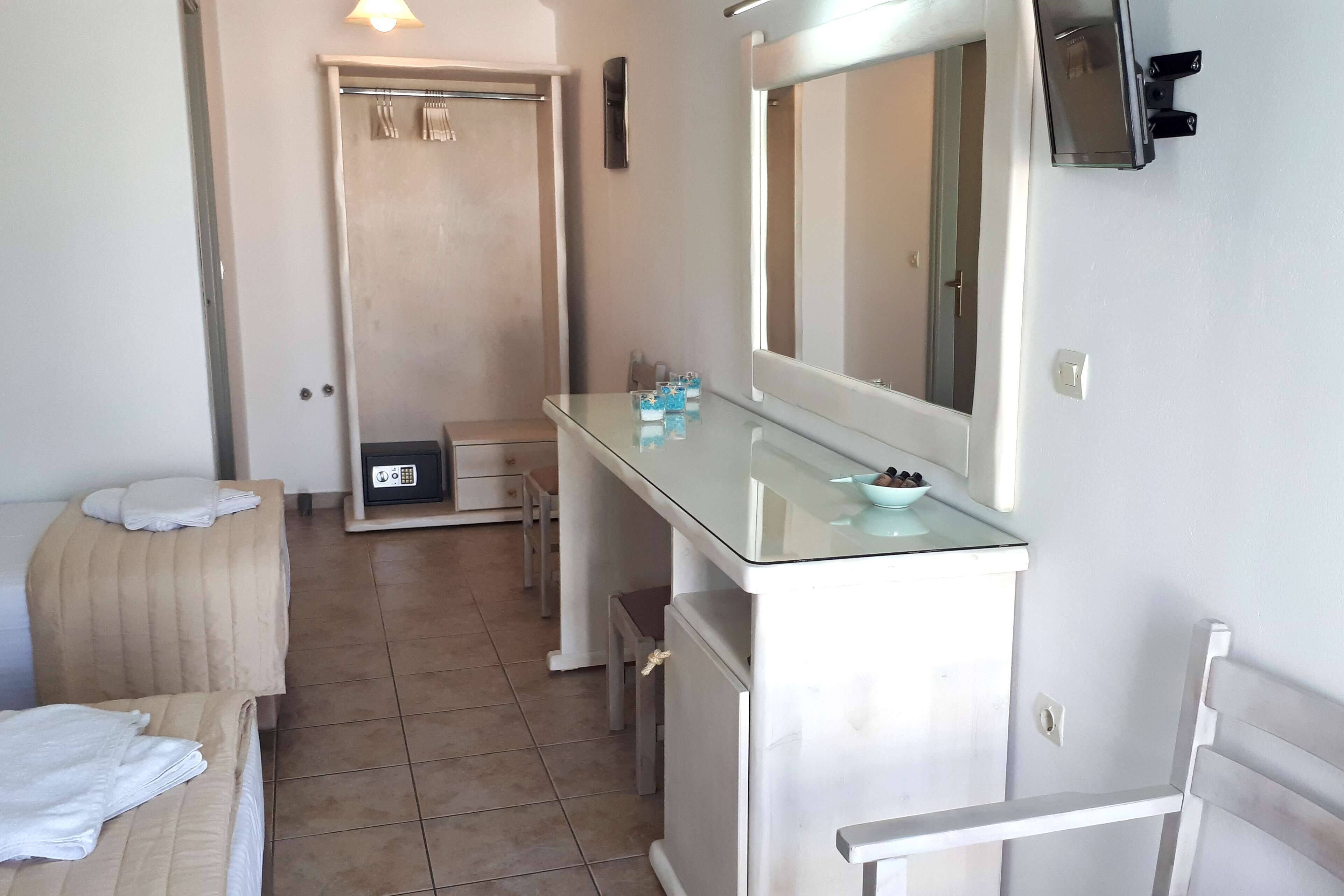 A bathroom with a glass vanity, a mirror, a towel rack, and a shower area.