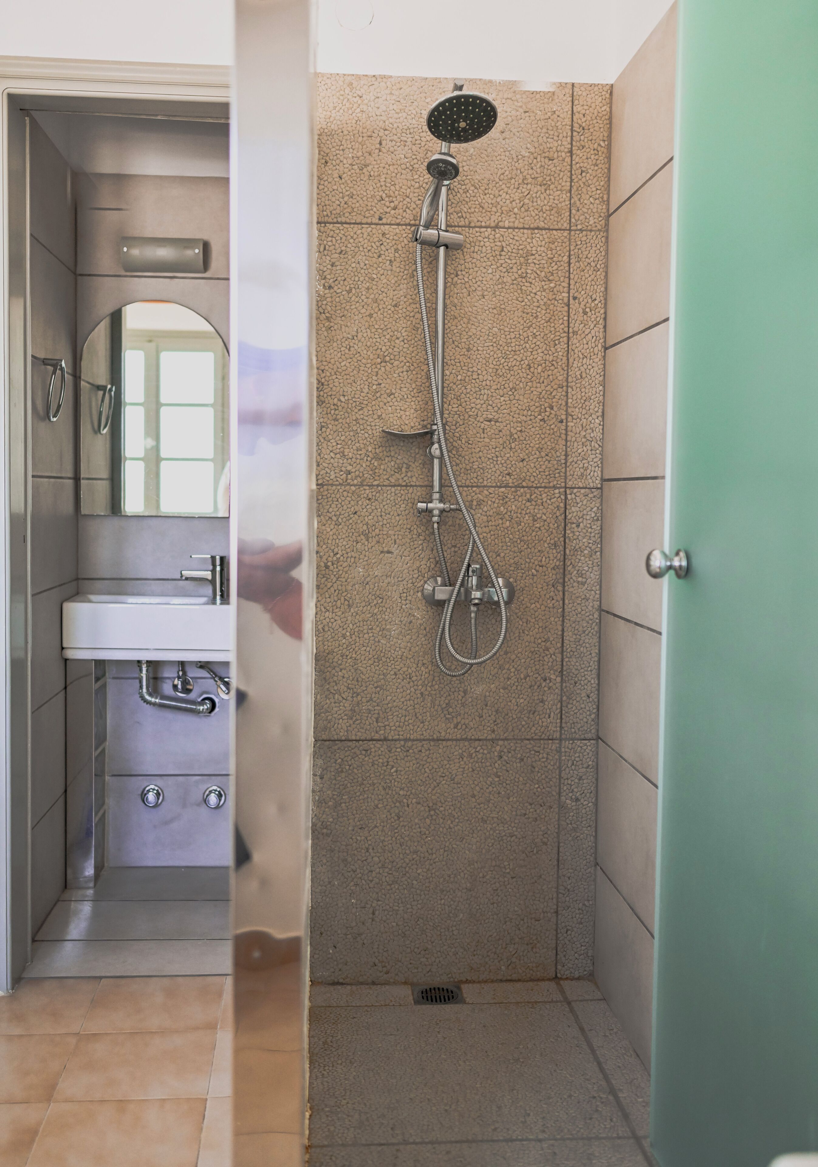 A bathroom with a sink, mirror, and shower.