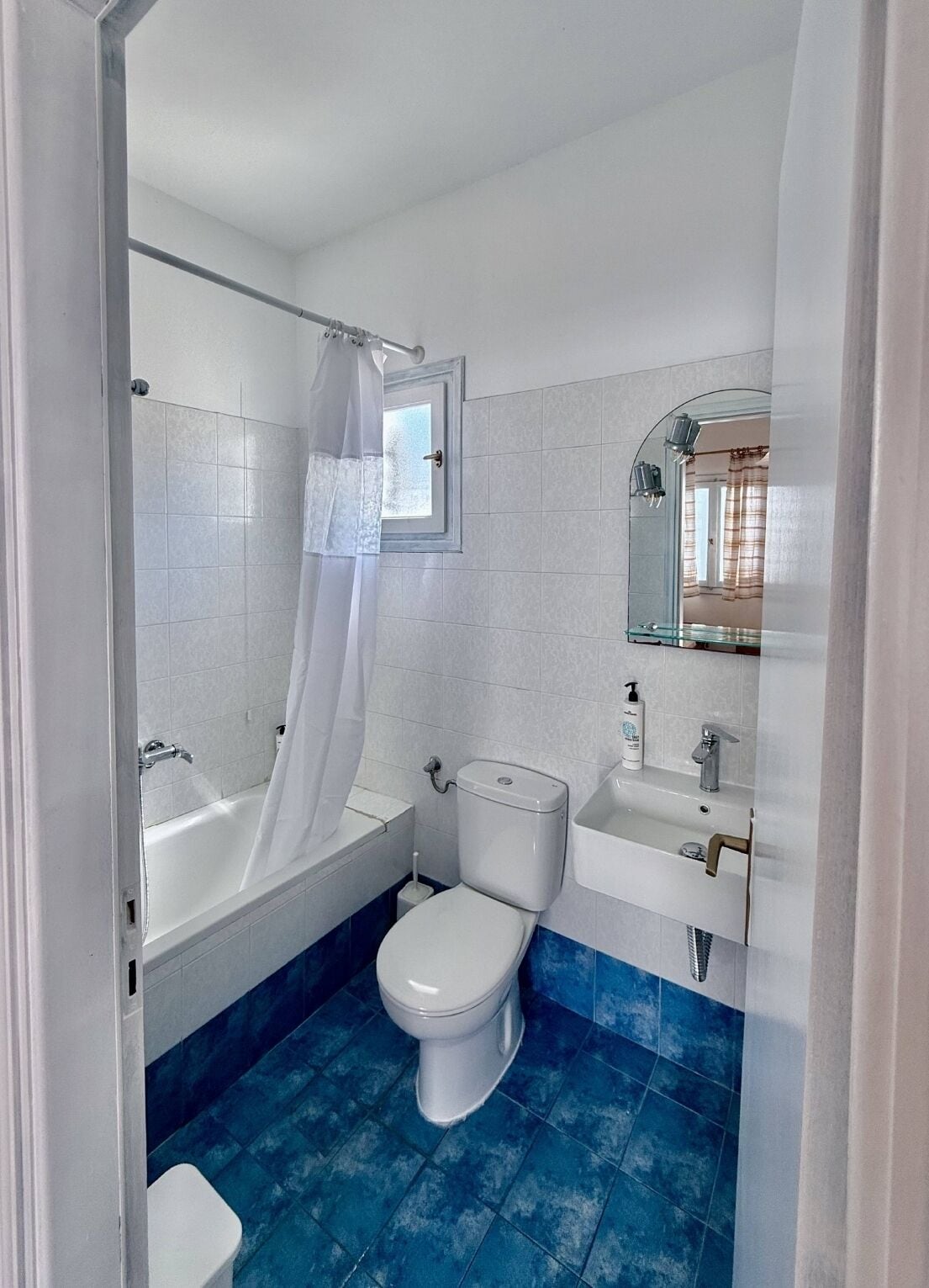 A bathroom with a bathtub, toilet, and sink.
