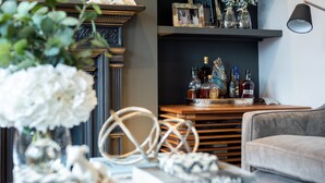 A living room with a fireplace, books, and decorative items. - Luxurious Wandsworth Home Close to Putney Heath by Underthedoormat (London)