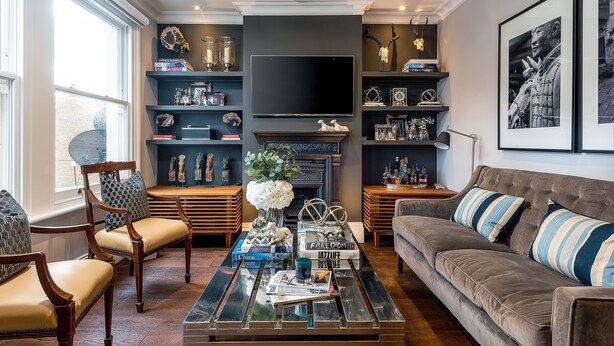 A living room with a fireplace, a television, and a bookshelf. - Luxurious Wandsworth Home Close to Putney Heath by Underthedoormat (London)